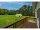 Deck overlooking a large backyard with a detached garage and lush green lawn at 225 Cantering Hills Ln, Summerville, SC 29483