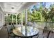 Screened porch with table and chairs, offering a relaxing view of lush greenery at 2340 Marsh Hen Dr, Seabrook Island, SC 29455
