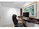 Bright home office features built-in desk and cabinetry, comfortable chair, and large artwork at 2340 Marsh Hen Dr, Seabrook Island, SC 29455
