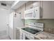 White appliances and granite countertops are featured in this kitchen at 1351 Pelican Watch Villas, Seabrook Island, SC 29455