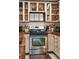 Rustic kitchen with white cabinets, gas range, and open shelving at 412 E Hudson Ave, Folly Beach, SC 29439