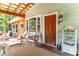 Inviting front porch with wooden door, wicker chairs, and a charming entryway at 412 E Hudson Ave, Folly Beach, SC 29439