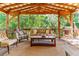 Relaxing covered porch with wooden ceiling, comfortable seating, and a view of lush greenery at 412 E Hudson Ave, Folly Beach, SC 29439