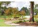 Curved pathway meanders through a park with benches and a water feature at 1687 Cultivation Ln # 461, Mount Pleasant, SC 29466