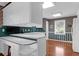 White kitchen with island, wood floors, and built-in desk at 10 Trail Hollow Dr, Charleston, SC 29414