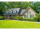 Brick home with a gray roof, green shutters, and well-manicured lawn at 10 Trail Hollow Dr, Charleston, SC 29414