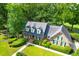Brick home with gray roof, surrounded by lush green trees and landscaping at 10 Trail Hollow Dr, Charleston, SC 29414