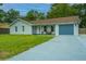 Newly renovated light gray house with a spacious gray driveway and lawn at 133 Marion Rd, Summerville, SC 29486