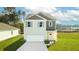Two-story house with gray and beige siding, white garage door, and landscaping at 5528 Bowmore Blvd, Ravenel, SC 29470