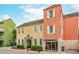 Two-story commercial building featuring yellow and coral exteriors, lush landscaping, and an arched entryway at 4402 Marblehead St, North Charleston, SC 29405