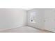 Bright bedroom with neutral walls and carpet, featuring a window with blinds and a door at 369 Willows Crescent Dr, Moncks Corner, SC 29461