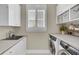 Bright laundry room features white shaker cabinets, quartz countertops, and modern washer/dryer at 239 Tupelo Lake Dr, Summerville, SC 29486