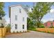 Three-story white house with gravel driveway and wooden fence at 72 Drake St # B, Charleston, SC 29403