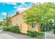 Charming yellow house with white picket fence and lush landscaping at 167 Coming St, Charleston, SC 29403
