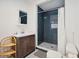 Bathroom with dark blue tile shower, white vanity, and white toilet at 167 Coming St, Charleston, SC 29403