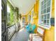 Bright yellow house with a porch and teal chairs at 167 Coming St, Charleston, SC 29403