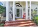 Front entrance with columns, brick steps, and a red rocking chair at 3427 Colonel Vanderhorst Cir, Mount Pleasant, SC 29466