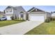 Tan house with a dark brown roof, white garage door, and landscaping at 182 Greenwich Dr, Summerville, SC 29486