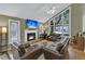 Living room with fireplace, large windows and leather sofas at 589 Oyster Rake Dr, Kiawah Island, SC 29455