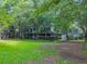 Two-story home with a wrap-around porch nestled in a wooded area at 200 Old Postern Rd, Summerville, SC 29483