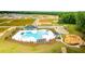 Aerial view of a community pool featuring unique design, lounge chairs, shade umbrellas and a playset nearby at 281 Blue Haw Dr, Moncks Corner, SC 29461