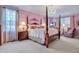 Peaceful main bedroom with a four-poster bed, soft pink walls, and ample natural light at 705 S Magnolia St, Summerville, SC 29483