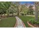 Landscaped front yard with stone pathway, lush greenery, and mature trees at 705 S Magnolia St, Summerville, SC 29483
