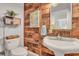 Charming bathroom with wood-paneled walls, pedestal sink, and toilet at 705 S Magnolia St, Summerville, SC 29483