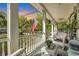 Spacious front porch with white railings, wicker furniture, and American flag at 705 S Magnolia St, Summerville, SC 29483