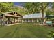 Large backyard with covered patio, lush lawn, and charming cottage at 705 S Magnolia St, Summerville, SC 29483