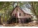 Two-story cottage, whimsical exterior paint, dark stairs, and lush landscaping at 218 E Huron Ave, Folly Beach, SC 29439