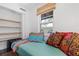 Small bedroom with twin bed, colorful pillows, and built-in shelving at 218 E Huron Ave, Folly Beach, SC 29439