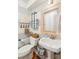 Clean bathroom with pedestal sink, wood-framed mirror, and striped walls at 933 Mccants Dr, Mount Pleasant, SC 29464