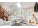 L-shaped living area with vaulted ceilings, skylights, and white sofas at 933 Mccants Dr, Mount Pleasant, SC 29464