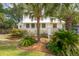 Charming white cottage with lush landscaping and a metal roof at 933 Mccants Dr, Mount Pleasant, SC 29464