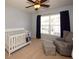 Bedroom with a crib, rocker, and large window at 2429 Scholar Ln, North Charleston, SC 29406