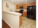 Kitchen with breakfast bar, black appliances, and wood cabinets at 2429 Scholar Ln, North Charleston, SC 29406