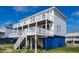 Beach house with side view of wrap-around deck and stairs at 144 Palmetto Blvd, Edisto Island, SC 29438
