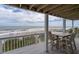 Enjoy the ocean view from this deck with table and chairs at 144 Palmetto Blvd, Edisto Island, SC 29438