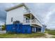 Elevated beach home with blue accents and multiple decks at 144 Palmetto Blvd, Edisto Island, SC 29438