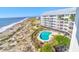 Oceanfront building with kidney-shaped pool, beach access, and palm trees at 9002 Palmetto Dr # 512, Isle of Palms, SC 29451