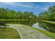 Curved walkway alongside a pond reflecting lush trees at 1710 Cayla St # 78, Johns Island, SC 29455