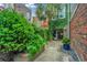 Private courtyard with lush greenery and brick pathway at 377 King St # 101, Charleston, SC 29401