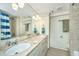 Bathroom with double vanity, marble countertop and tiled shower at 377 King St # 101, Charleston, SC 29401