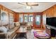 Living room featuring wood paneling, sectional sofa, and TV at 924 W Oceanview Rd, Charleston, SC 29412