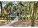 Home surrounded by mature trees and landscaping, featuring a white staircase and walkway at 2981 Deer Point Dr, Seabrook Island, SC 29455