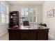 Home office with large desk, bookcase, and window with plantation shutters at 5559 Colonial Chatsworth Cir, North Charleston, SC 29418