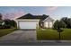 Tan house with a white garage door and landscaping at 586 Eastern Isle Ave, Summerville, SC 29486
