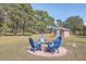 Fire pit area with blue chairs surrounded by trees and a brick shed at 1090 Peru Rd, Saint Stephen, SC 29479