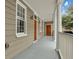 Bright and airy front porch with light grey floor and wooden doors at 59 Ashe St, Charleston, SC 29403